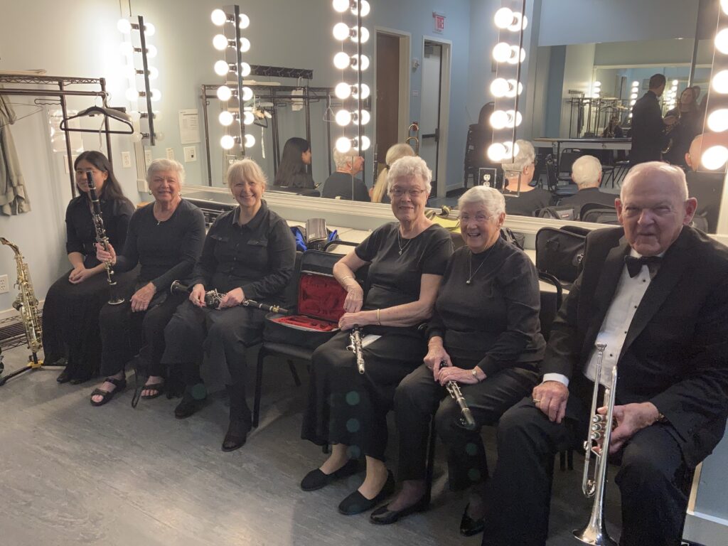 group of musicians seated together before a concert