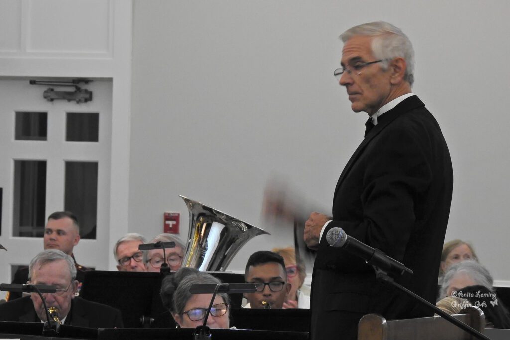 Conductor at podium conducting wind symphony