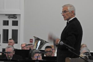 Conductor at podium conducting wind symphony