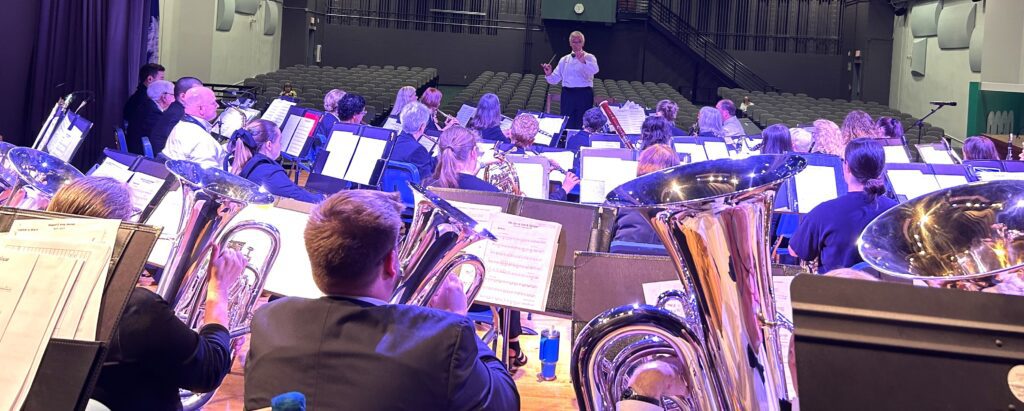 Director conducts wind symphony in practice